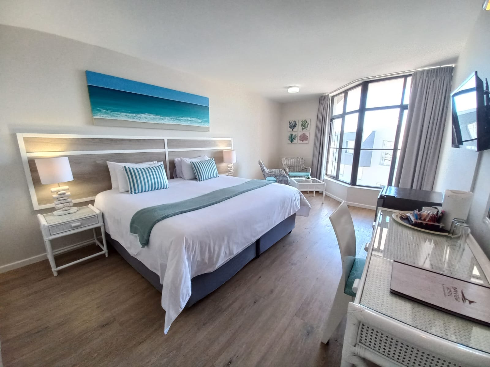 classic hotel room with satellite TV and seating area with views over plettenberg bay