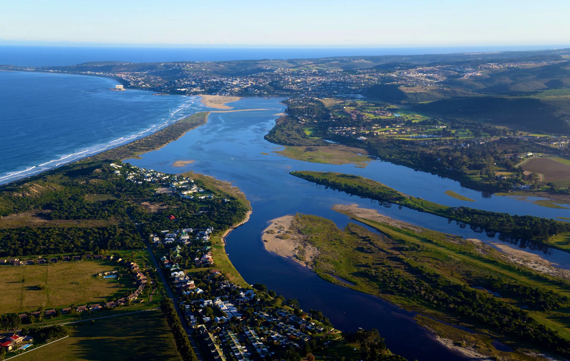aerial view over the lagoon flowing into plettenberg bay sea