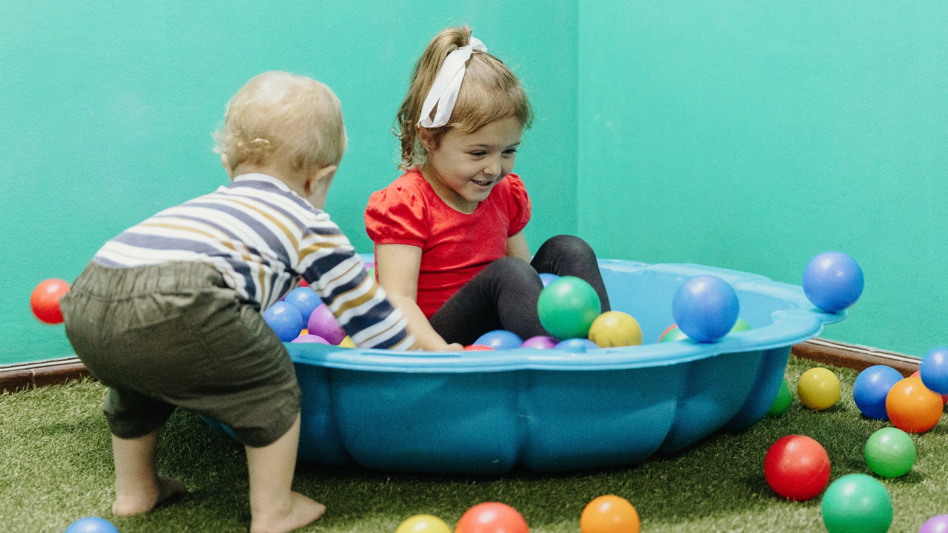 young children playing in a shell ball pit