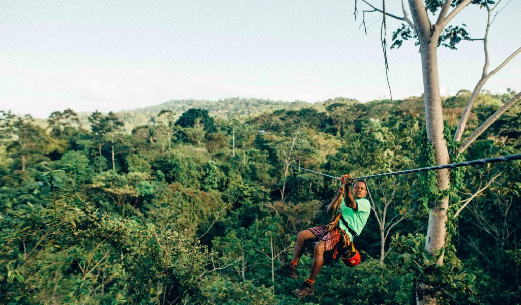 a man abseiling through tree-top canopies