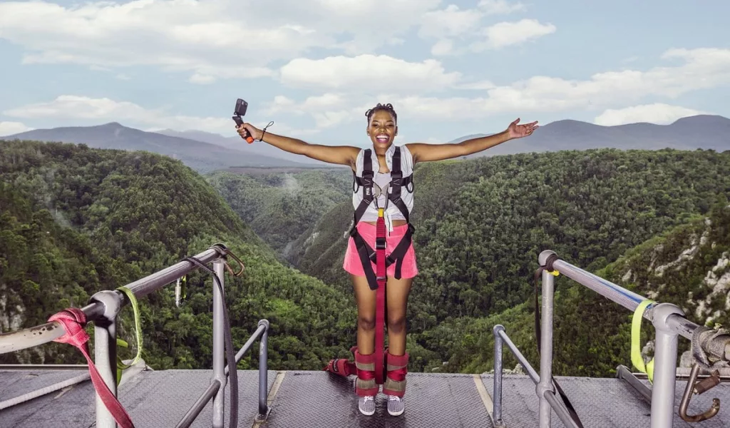 front view of a young smiling woman about to bungy jump